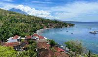 Pemandangan pesisir pantai di Karangasem, Bali, dengan perairan biru dan latar perbukitan hijau serta Gunung Agung. Berdasarkan data Prakiraan Cuaca Bali BMKG, kawasan ini diprediksi akan mulai diselimuti udara kabur menjelang akhir pekan. Foto: Attila Tokolics/Unsplash.