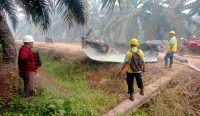 Tiga pekerja perkebunan mengenakan helm proyek sedang mengamati bongkahan logam raksasa misterius yang diduga sebagai Sampah Antariksa Kotim, jatuh teronggok di jalan tanah area kebun sawit PT Agro Bukit. Kredit Foto: Warga/Istimewa.