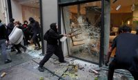 Seorang demonstran bertopeng menghancurkan kaca jendela toko menggunakan kursi selama kerusuhan Prancis, diperkirakan 2.000 toko dijarah di seluruh negeri. Foto oleh Carl Court/Getty Images.