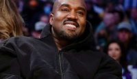 Potret rapper Kanye West alias Ye yang tersenyum mengenakan jaket hoodie hitam di Los Angeles pada tahun 2022. Rencana Konser Kanye West di Rusia baru-baru ini resmi dibatalkan akibat rekam jejaknya terkait isu glorifikasi Adolf Hitler. (Kredit Foto: Dokumentasi)