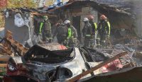 Tim penyelamat memeriksa puing-puing rumah warga dan mobil yang hangus akibat serangan udara Rusia di Kharkiv pada hari Minggu, sebuah realitas yang membantah klaim sepihak soal Gencatan Senjata Ukraina. (Kredit Foto: Vyacheslav Madiyevskyy/Reuters)