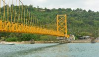 Pemandangan Jembatan Kuning penghubung Nusa Lembongan dan Nusa Ceningan di Klungkung di bawah langit cerah, selaras dengan pantauan Prakiraan Cuaca Bali terkini. Kredit: Wayan Sudiarta/UNSPLASH.COM